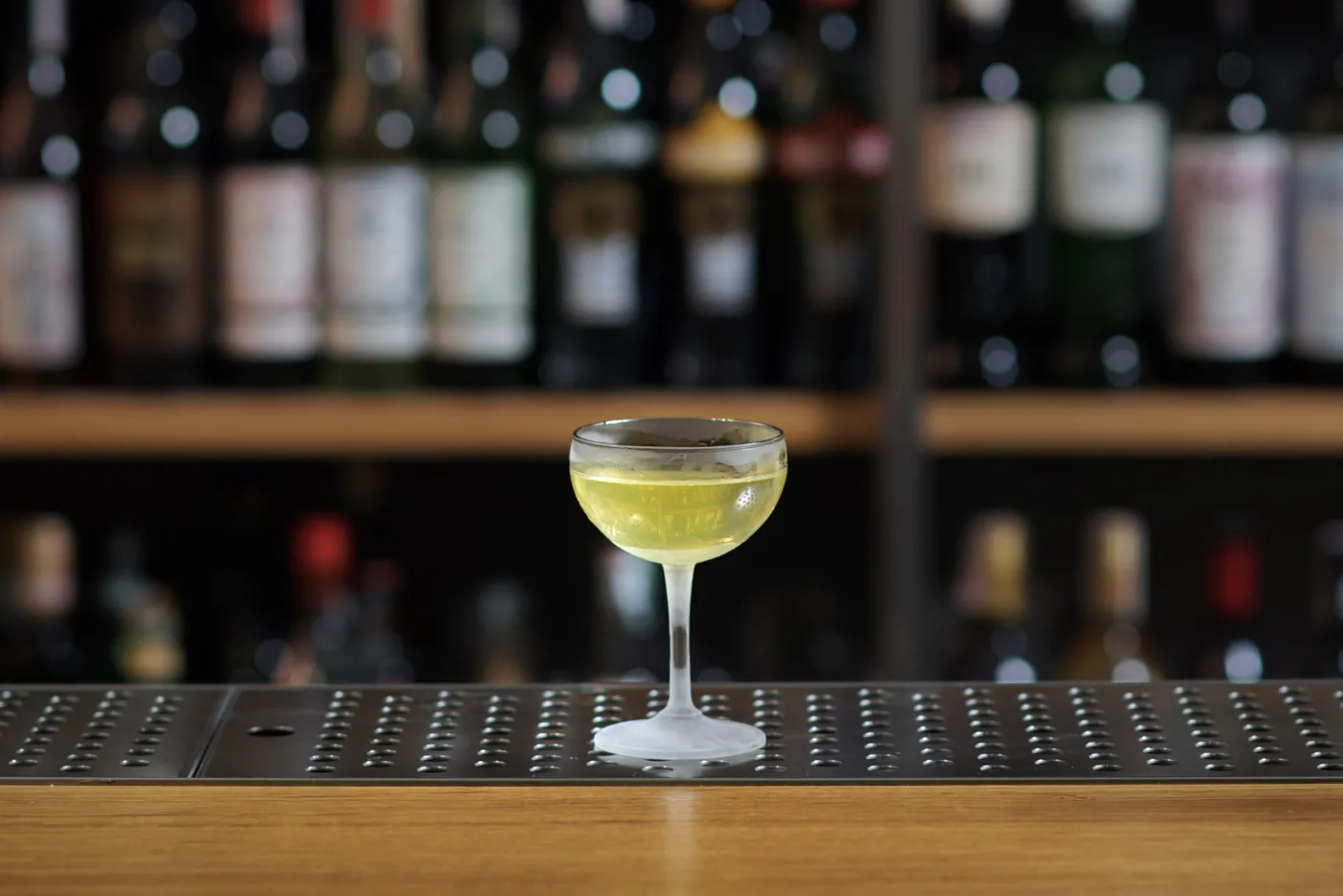Alaska giallo chiaro in coppetta da cocktail su banco bar