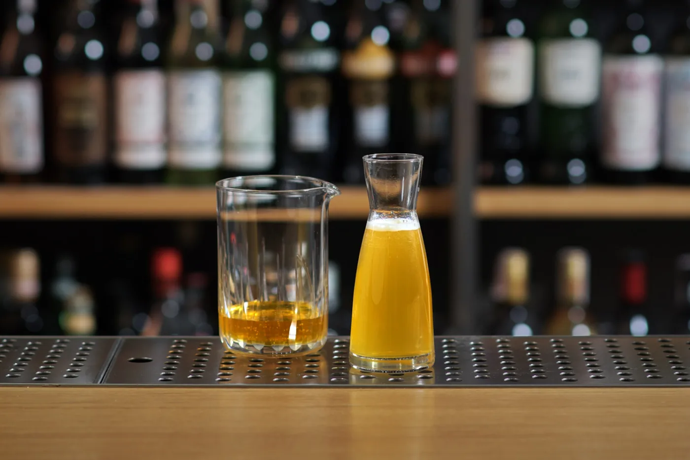 Mixing glass con miele e caraffina di honey mix sul banco del bar