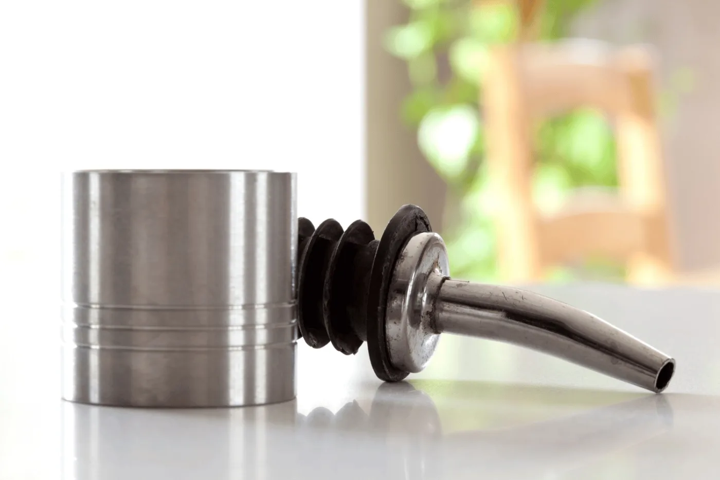 Jigger, metal pourer e bottiglie sul bancone durante il dosaggio di un cocktail