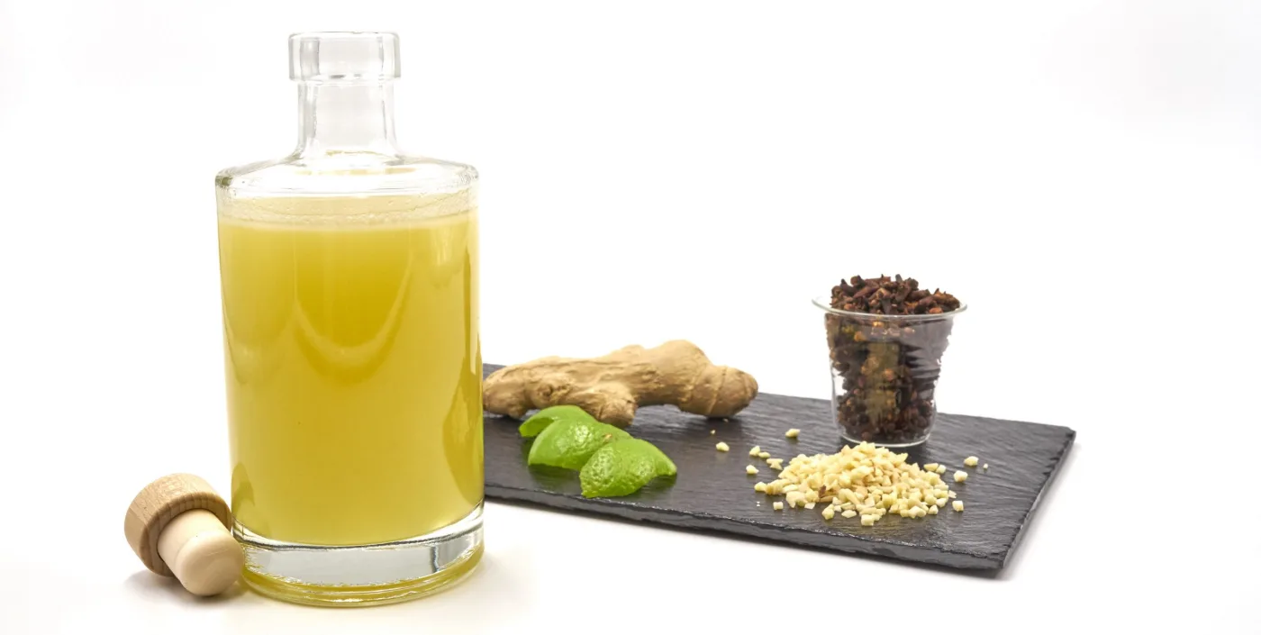 Bottiglia di falernum home made con zenzero, lime, chiodi di garofano e mandorle tritate