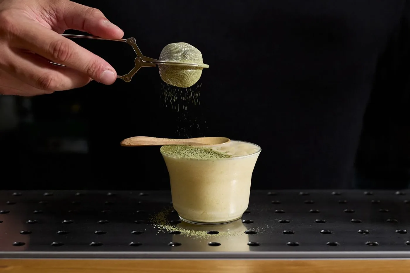 Spolverata di polvere di lime essiccato sulla Freezer Colada cremosa servita in bicchiere basso con cucchiaino di legno
