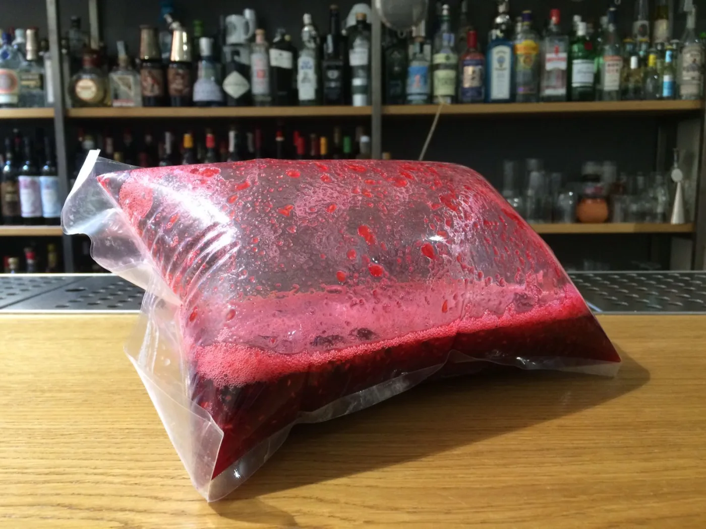 Sacchetto sottovuoto gonfio con premix ai frutti di bosco in fermentazione sul banco bar
