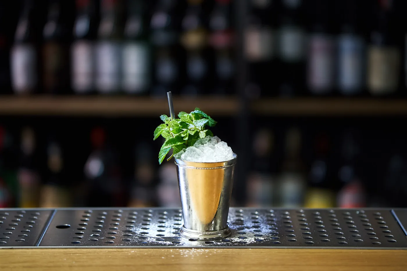 Mint Julep in silver mug con ghiaccio tritato e mazzetto di menta su banco bar