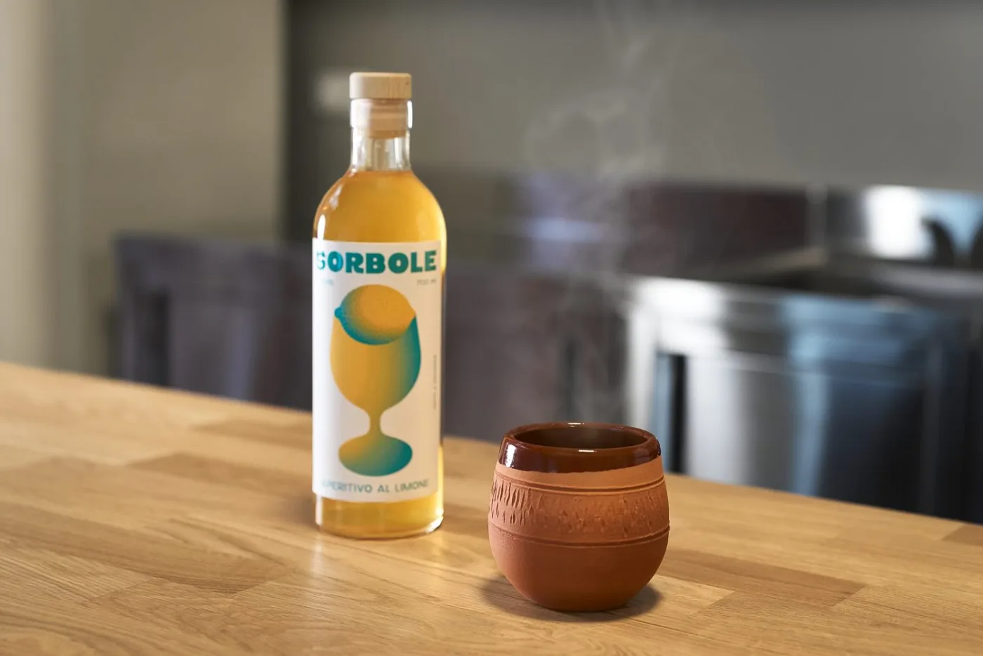 Sorbole Grog fumante servito in tazza di terracotta accanto alla bottiglia di Sorbole