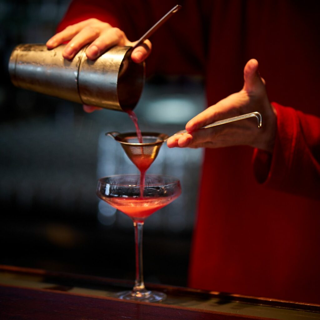 Mirco versa il cocktail Violet Isle dallo shaker