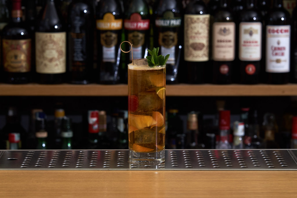 Un tumbler alto contenente Pimm's Cup. Un long drink preparato con Pimm's n°1, Ginger Ale, e frutta fresca