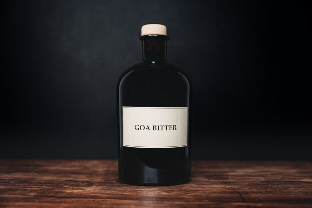 Una bottiglie di Goa Bitter, liquore amaro al profumo di india a base cardamomo, mirra, pepe verde e basilico santo (tulsi)