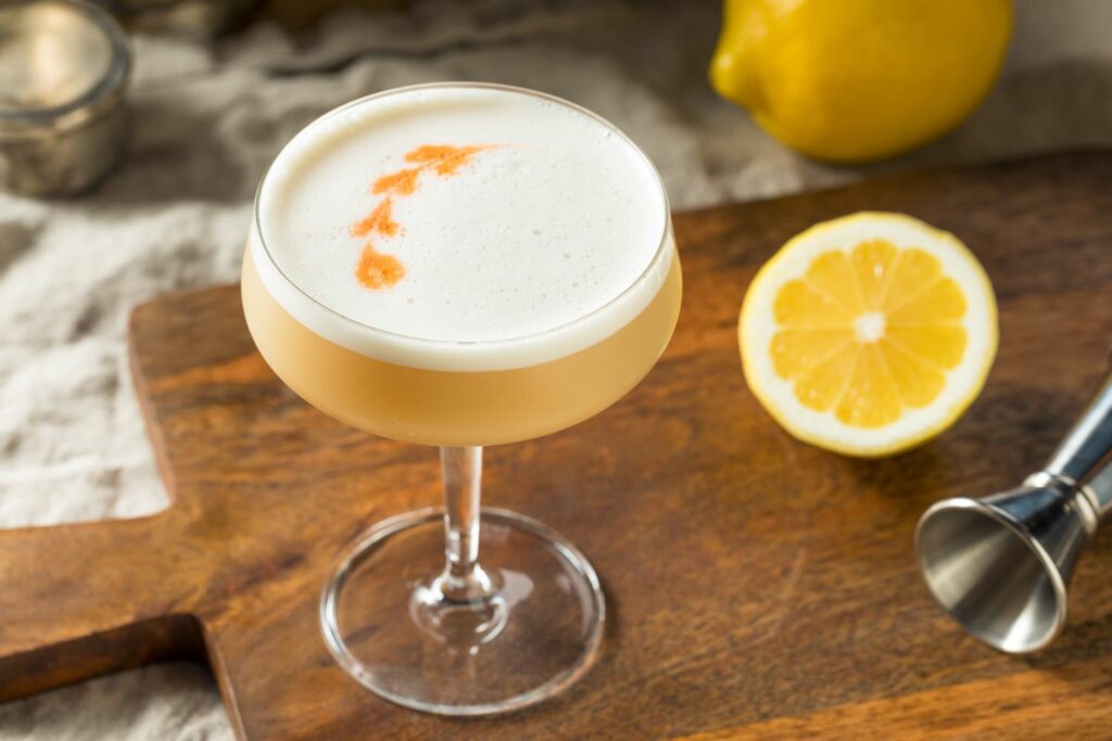 Delle gocce di bitters su un cocktail sour