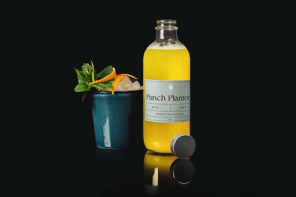 Punch Planteur, liquore tropicale a base di Rhum agricole e frutta tropicale. Viene presentato in bottiglia e come singolo drink in una mug in ceramica decorata con un rametto di menta e delle scorze di arancia.