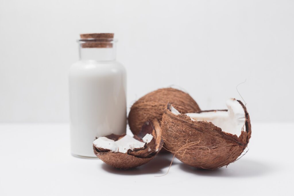 un cocco aperto e latte di cocco, ingrediente per cocktail