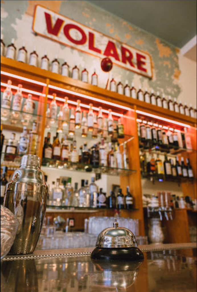 dettaglio del banco bar del bar Volare di Bologna. Sullo sfondo la bottigliera e l'insegna del bar.