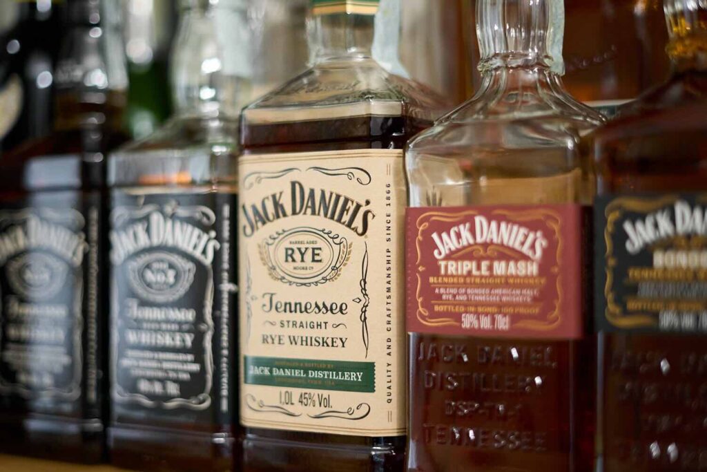 Su una bottigliera 3 bottiglie di Jack Daniel's: Old n°7, Tennessee Rye e Triple Mash.