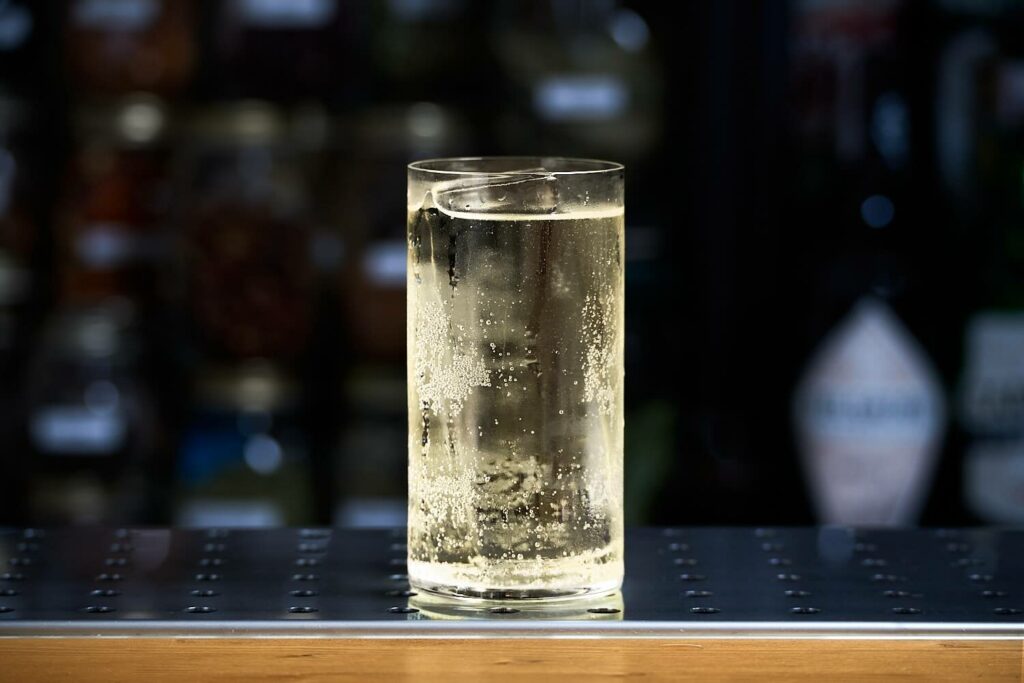 Su un banco bar il cocktail long drink "Signora i Limoni". Il cocktail si presenta in un bicchiere da long drink con all'interno una stecca di ghiaccio.