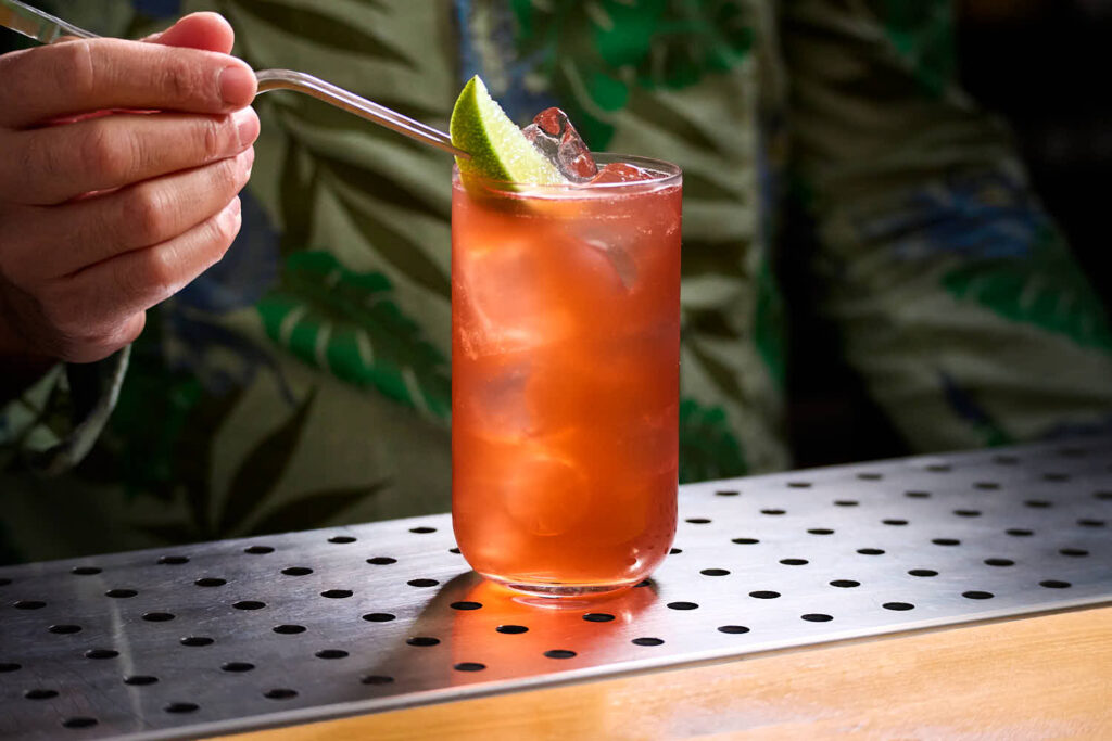 Su un banco bar il cocktail Tiki "Mexican El Diablo" di Trader Vic. Preparato con Tequila, succo fresco di Lime, Creme de cassis e Ginger Ale