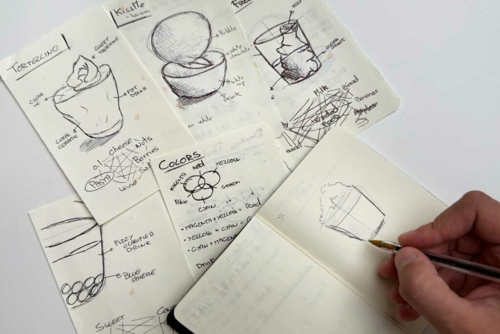 alcune pagine di un taccuino di un bartender con dei bozzetti di progetti di ricette di cocktail